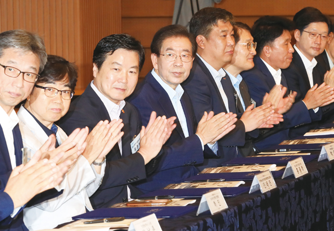 7월 25일 오전 서울 중구 대한상공회의소에서 열린 ‘소상공인 수수료 부담 제로 결제 서비스’ 도입을 위한 업무협약식에서 홍종학 중소벤처기업부 장관(왼쪽 세 번째), 박원순 서울시장(왼쪽 네 번째) 등의 참석자들이 손뼉를 치고 있다. 사진 연합뉴스