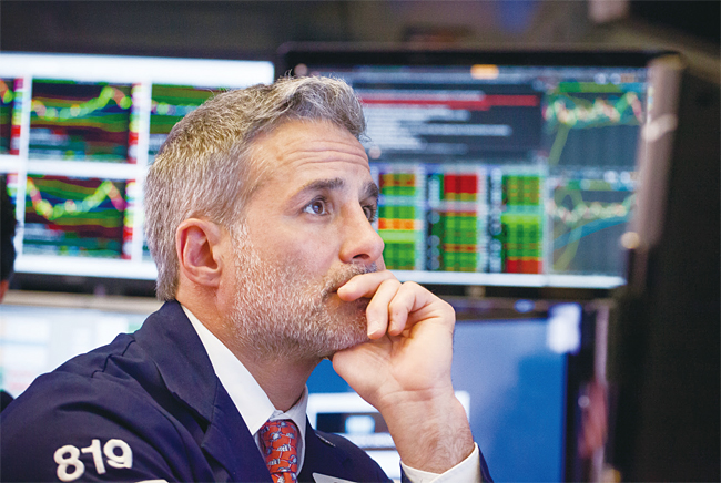 뉴욕증권거래소(NYSE)에서 한 트레이더가 모니터 화면을 응시하고 있다. 사진 블룸버그