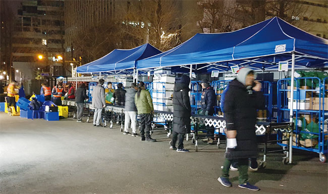 12일 오전 0시 30분 서울 뚝섬 인근에 있는 쿠팡 물류창고에서 플렉서들이 물건을 분류하고 있다. 이날 모인 플렉서는 15명이다. 사진 김소희 기자