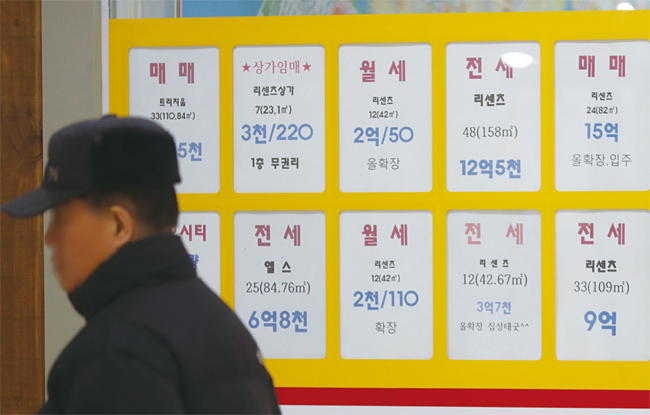 지난 3일 서울의 한 부동산 중개업소 앞을 한 사람이 지나가고 있다. 최근 집값과 전셋값이 하락해 일부 지역에선 집을 팔아도 전세보증금에 모자란 ‘깡통전세’마저 나타났다. 사진 연합뉴스