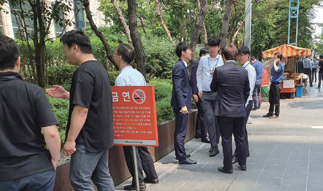 6월 4일 오전 서울 여의도 증권가 빌딩 사이 ‘너구리 골목’ 금연 표지판 앞에서 직장인들이 담배를 태우고 있다. 사진 김문관 기자