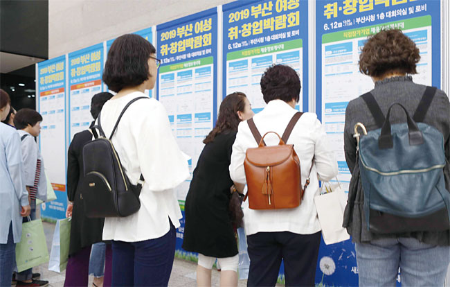 12일 부산시청 1층 로비에서 열린 ‘부산 여성 취·창업박람회’에서 구직 여성들이 채용정보를 살펴보고 있다. 사진 연합뉴스