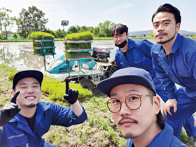 네 명의 청년이 논을 배경으로 사진을 찍고 있다. (오른쪽 앞부터 시계 방향)고성용 대표, 정덕영 실장, 이상욱 이사, 이한순 실장. 사진 한강주조
