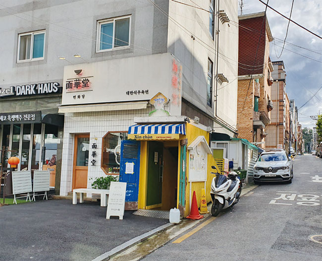 샤로수길에 있는 생맥주 전문점, 대만식 우육면 가게 뒤로 낡은 벽돌 빌라가 들어서 있다. 사진 김소희 기자