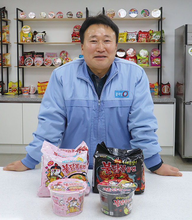 박성관 2000년 삼양식품연구소 면 개발팀 입사, 2012년 개발팀장(총괄), 2018년 연구소장 / 박성관 삼양식품연구소 소장이 불닭 브랜드 가운데 판매량 1·2위인 오리지널 불닭볶음면과 까르보 불닭볶음면 앞에서 포즈를 취하고 있다. 사진 전준범 기자
