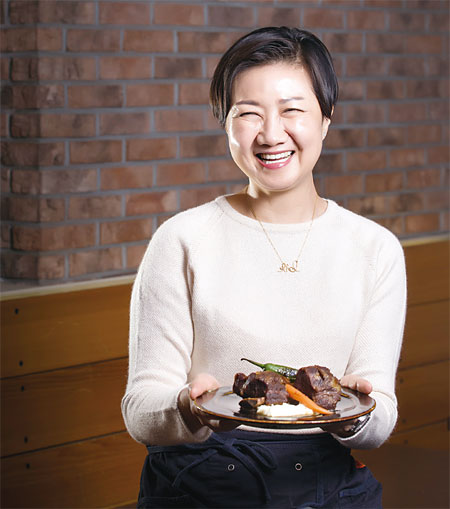 서울 이촌동 가정식 전문점 수퍼판의 우정욱 대표가 요리를 들고 활짝 웃고 있다. 사진 조선일보 DB
