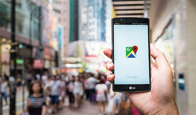 한 사람이 홍콩의 번화한 거리에서 길을 찾기 위해 구글맵을 켜고 있다.