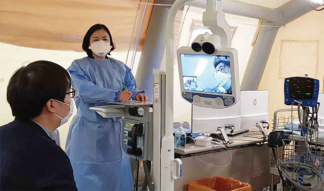 경기도 고양시 명지병원이 신종 코로나 바이러스 감염증(코로나19) 확산 방지를 위해 운영하는 선별진료소에서 안전한 선별진료를 위해 로봇을 이용한 원격진료를 시행하고 있다. 사진 연합뉴스