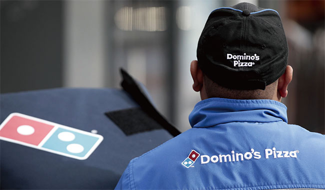 도미노 피자는 미국 최초로 피자 배달 서비스를 선보이면서 ‘피자=배달음식’이라는 공식을 만들었다. 사진은 영국의 도미노 피자 배달원의 뒷모습. 사진 블룸버그