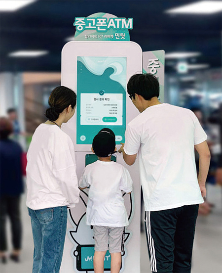 한 가족이 SK네트웍스의 중고폰 거래 전용 ATM을 사용하고 있다. 사진 SK네트웍스