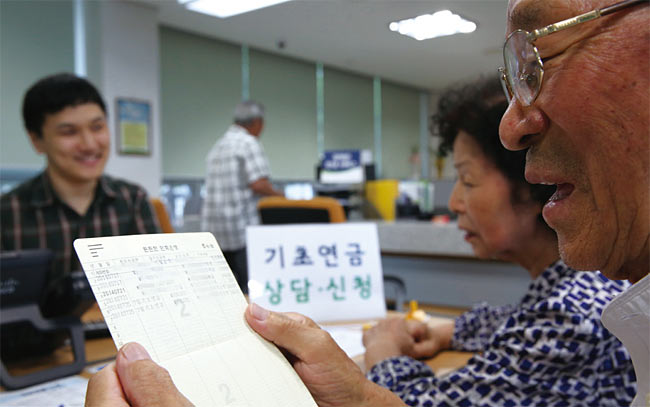 기초연금은 현재 시행되고 있는 대표적인 현금성 복지제도다. 사진은 기초연금을 처음 지급한 2014년 7월 25일 서울 강북의 한 주민센터에서 노인 부부가 수령액을 확인하고 있는 모습. 사진 조선일보 DB