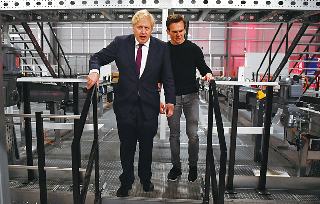 보리스 존슨(왼쪽) 영국 총리가 2019년 12월 10일(현지시각) 영국 워링턴에 있는 디허트그룹(THG)의 물류센터에 방문해 매튜 몰딩 THG CEO와 이야기를 나누고 있다. 사진 디허트그룹