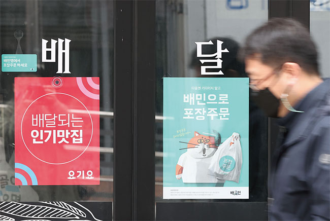 2020년 12월 29일 오후 서울 시내 한 음식점에 나란히 부착된 배달의민족과 요기요 광고. 사진 연합뉴스