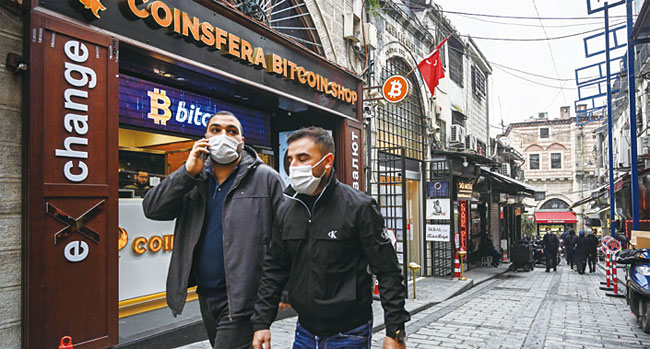 사람들이 터키 이스탄불의 한 가상화폐 거래소 앞을 지나가고 있다. 사진 AFP연합