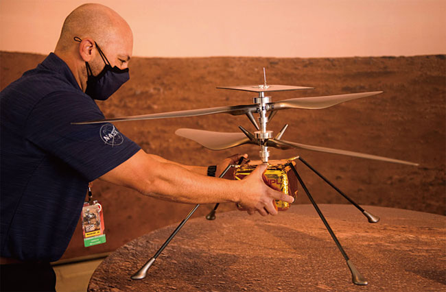 NASA 직원이 ‘퍼시비어런스’와 함께 화성으로 날아가 동력 비행에 나서는 소형 헬리콥터 ‘인지뉴어티(Ingenuity)’를 소개하고 있다. 사진 AFP연합