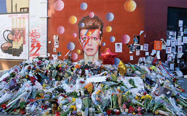 영국 런던에서 시민들이 데이비드 보위를 추모하기 위해 그의 얼굴이 그려진 벽화 앞에 꽃을 선물했다.