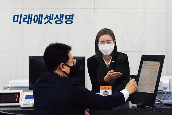 미래에셋생명 창구를 방문한 고객과 직원이 디지털 터치 모니터를 통해 업무를 처리하고 있다. 미래에셋생명은 작년 12월 보험 업계 최초로 종이 없는 창구 시스템을 도입했다. 사진 미래에셋생명