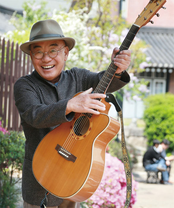 가수 이장희가 통기타를 들고 환하게 웃고 있다. 사진 조선일보 DB