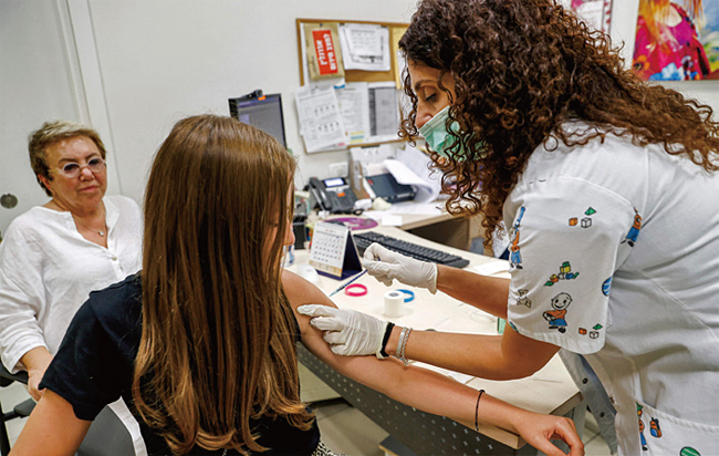한 이스라엘 여성이 백신을 접종하고 있다. 사진 AFP연합