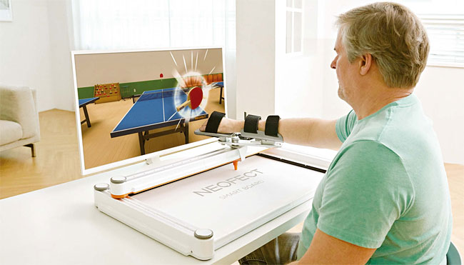 한 남성이 네오펙트에서 개발한 상지(팔) 재활 기기 ‘스마트 보드’를 사용하고 있다. 사진 네오펙트