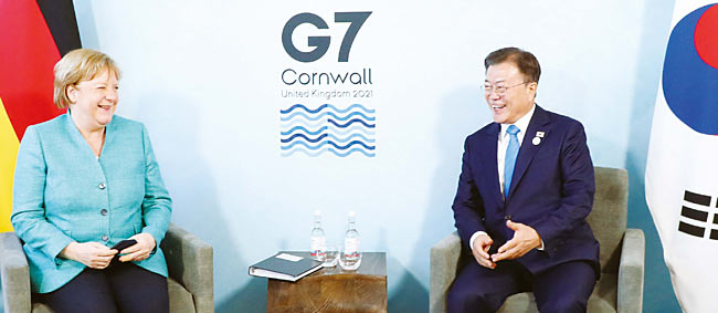 주요 7개국(G7) 정상회의 참석차 영국을 방문한 문재인(오른쪽) 대통령이 6월 12일(현지시각) 영국 콘월 카비스베이 양자회담장에서 앙겔라 메르켈 독일 총리와 대화하고 있다. 사진 AP연합