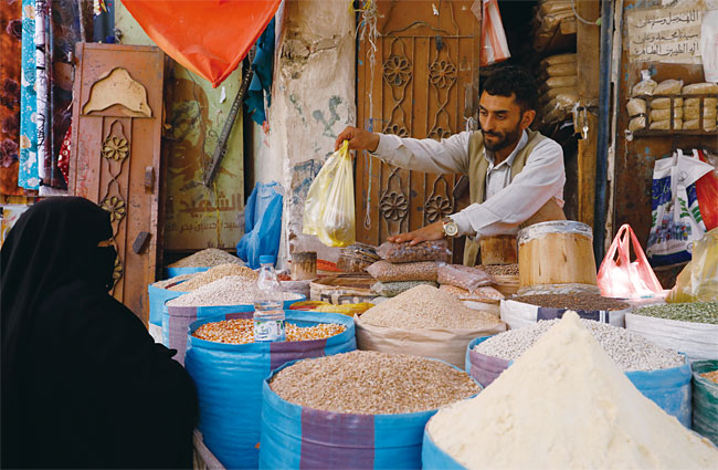 예멘 수도의 한 전통시장에서 상인이 여성 고객에게 곡물을 팔고 있다. 유엔식량농업기구(FAO)는 예멘 등 밀 수입 의존도가 높은 비개발국가들이 러시아와 우크라이나의 전쟁으로 큰 경제적 타격을 입을 것이라 지적했다. EPA연합