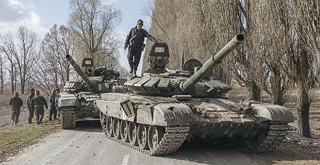 3월 27일(현지시각) 우크라이나 수도 키이우(키예프) 외곽에서 한 우크라이나 병사가 전투를 벌여 노획한 러시아군 탱크 위에 서 있다. 우크라이나 국방부는 키이우 주변 지역에서 러시아군 일부를 35∼70㎞ 이상 몰아냈다고 밝혔다. 사진 로이터연합