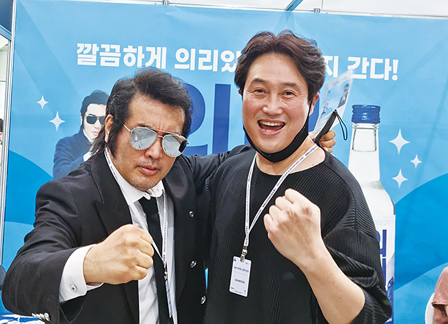 2022년 7월 열린 한 주류박람회장에서 김보성(오른쪽)부국상사 대표가 같은 이름의 배우 김보성과 함께 만든 ‘의리남’ 소주 부스에서 ‘의리’를 외치고 있다. 사진 박순욱 기자