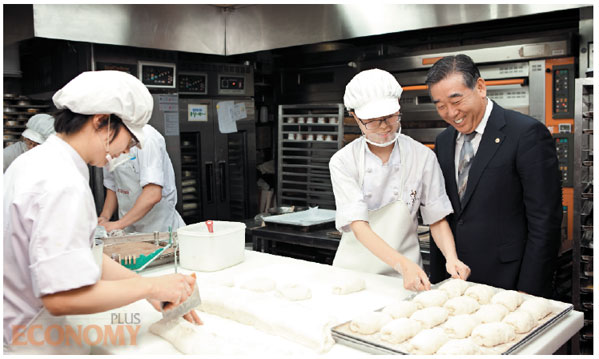 - 김영모 회장(맨 오른쪽)이 도곡타워점 2층 작업장에서 제빵사들과 얘기를 나누고 있다. 그는 위생복과 위생모가 없다는 이유로 밀가루 반죽에 손을 대지 않았다.