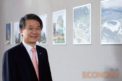 - 한미글로벌이 CM을 수행한 프로젝트 현장 사진이 걸려있는 벽면 앞에서 활짝 웃고 있는 김종훈 회장.
