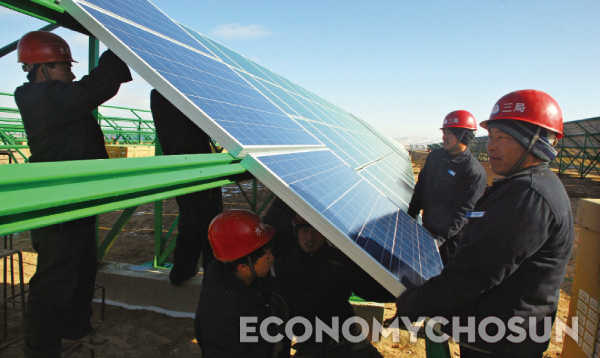 중국정부는 서부 내륙 지역을 친환경 산업단지로 개발 중이다. 사진은 간쑤성 둔황에서 기술자들이 태양광 발전용 태양전지 패널을 설치하는 모습.