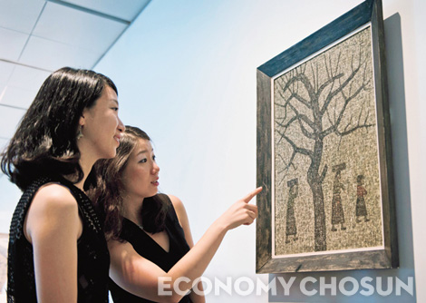 미술 애호가들이 지난해 9월 뉴욕 크리스티 경매에 출품돼 22억4000만원에 낙찰된 박수근의 작품 ‘나무와 세여인’을 감상하고 있다.