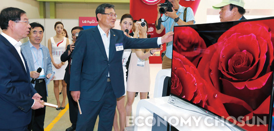 지난 8월 서울 코엑스에서 열린 ‘스마트 클라우드쇼 2013’에 참석한 최문기 미래창조과학부 장관이 초고화질 곡면 OLED TV를 만져보고 있다. 맨 왼쪽은 행사에 함께 참석한 박원순 서울시장.