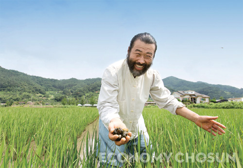 - 노대성 대표가 우렁이 농법으로 벼농사를 짓는 논에서 환하게 웃고 있다.