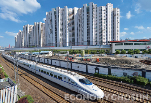 - 중국 상하이에서 고속철도 차량 한 대가 고층 주거 빌딩 옆을 달리고 있다. 이다이 이루 정책으로 철도 업종이 수혜주로 떠오르고 있다.