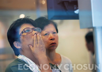 - 지난 7월9일 한 홍콩 시민이 은행에 내걸린 증시 정보를 심각하게 살펴보고 있다.