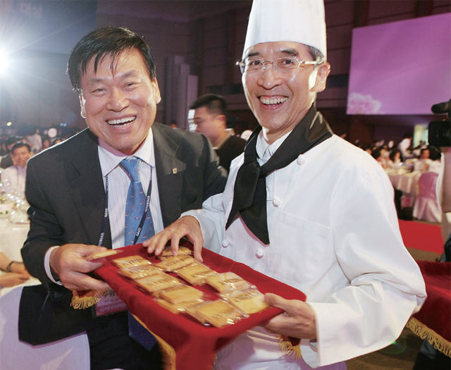 신창재 회장(오른쪽)이 2008년 고객보장대상 시상식에서 파티쉐로 변신해 직접 구운 쿠키를 나눠주고 있다.