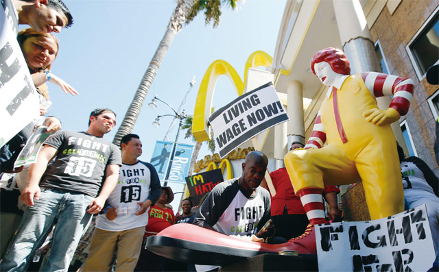 미국 로스앤젤레스(LA)의 한 맥도널드 매장 앞에서 종업원들이최저임금 인상을 요구하며 시위를 벌이고 있다. <사진 : 블룸버그>