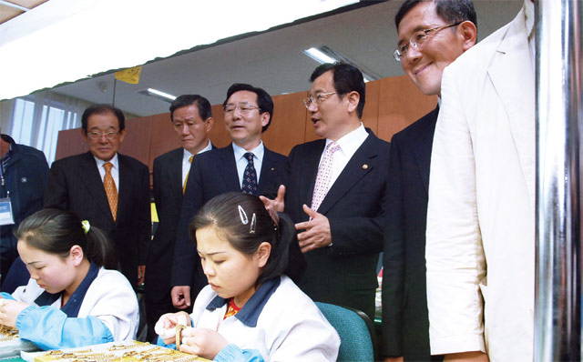 김기문 회장(사진 가운데)이 2007년 중소기업중앙회 회장 재직 시 개성공단을 방문, 한 생산라인을 둘러보고 있다. <사진 : 제이에스티나>