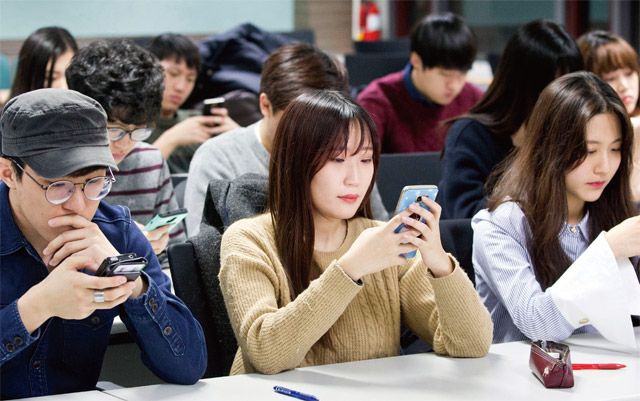 스마트폰과 소셜네트워크서비스가 보편화되면서 광고 형식과 제작 방식이 변화를 맞고 있다. 서울의 한 대학 재학생들이 강의실에서 스마트폰을 보고 있다. <사진 : 조선일보 DB>