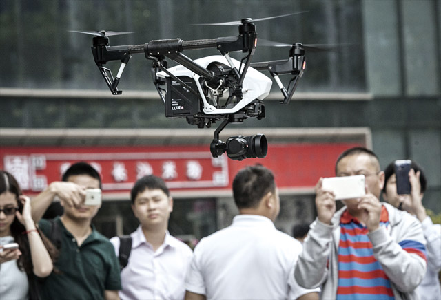 중국 DJI는 현재 전 세계 상업용 드론 시장의 70%를 장악하고 있다. 사진은 올해 4월 중국 선전 DJI 본사 앞에서 진행된 신형 드론 인스파이어 1의 시범 비행을 지켜보는 시민들의 모습. <사진 : 블룸버그>