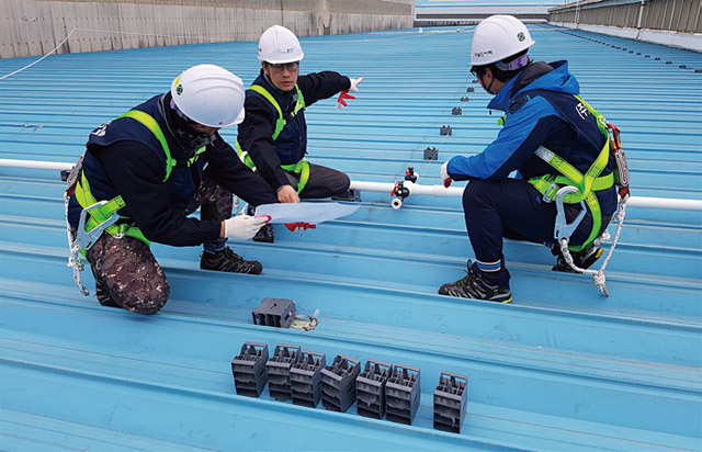 월드비텍 직원들이 건물 지붕에서 스프링쿨 장치를 설치하고 있다. <사진 : 월드비텍>