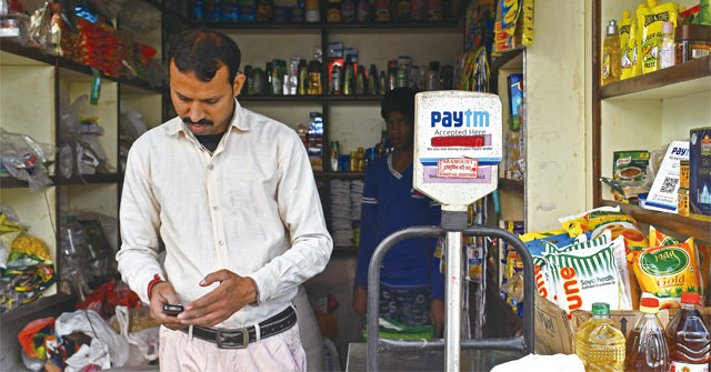 2016년 11월 인도 델리의 식료품점에서 남성 소비자가 상품을 사고 페이티엠으로 결제하고 있다. 인도에선 모디 총리의 화폐개혁 이후 페이티엠을 이용한 전자결제가 크게 늘었다. <사진 : 블룸버그>