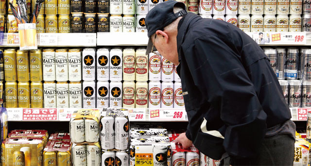 일본 사이타마현의 수퍼마켓에서 한 고령의 남성이 맥주를 집어 들고 있다. 인구가 감소하고 있는 일본에선 청년들이 맥주를 기피하는 현상까지 겹쳐 맥주 출하량이 12년 연속 역대 최저치를 경신했다. <사진 : 블룸버그>