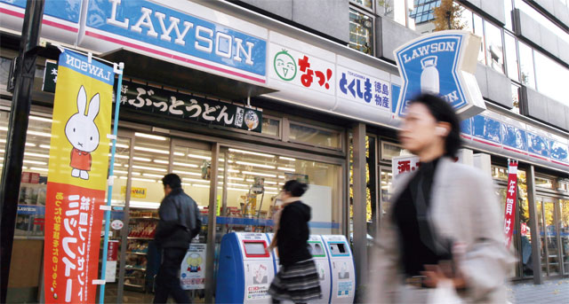 도쿄의 한 로손 편의점 앞을 행인이 지나가고 있다. 로손은 일본에서 세 번째로 큰 편의점 업체다. <사진 : 블룸버그>