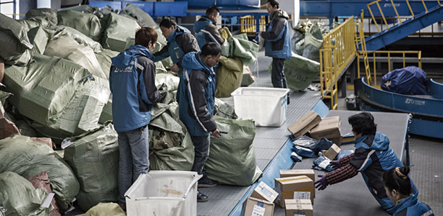 지난 2월 중국 상하이의 ZTO익스프레스 물류센터에서 직원들이 택배 상자를 분류하고 있다. <사진 : 블룸버그>