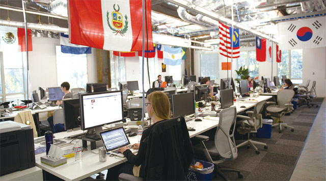 2011년 미국 캘리포니아주 멘로파크에 위치한 페이스북 본사 사무실에서 직원들이 일하고 있다. 천장에 여러 나라의 국기가 걸려 있다. <사진 : 블룸버그>