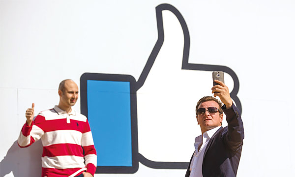 미국 캘리포니아주 멘로파크에 있는 페이스북 본사에서 방문객들이 대형 ‘좋아요’ 간판 앞에서 기념촬영을 하고 있다. <사진 : 블룸버그>