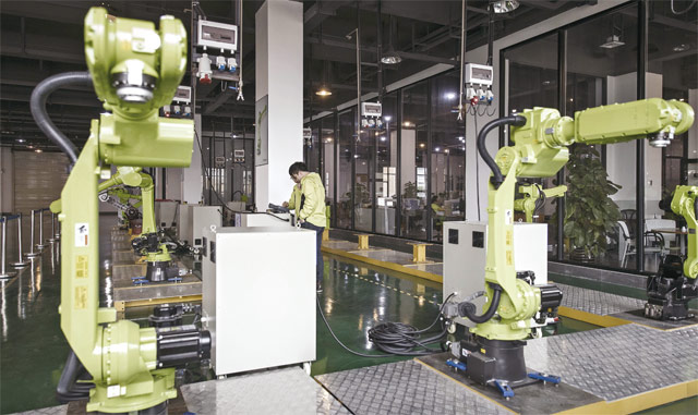 중국 포산에 있는 닝보웡 과학기술유한회사의 자회사인 광둥이수에송(E-디오다)의 기술자가 올해 2월 공개한 산업용 자동화 로봇을 시험하고 있다. <사진 : 블룸버그>