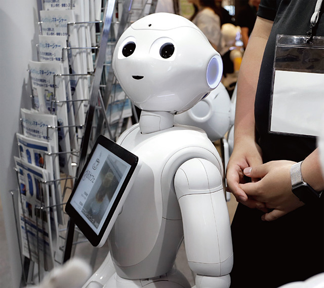 지난 6월 일본 도쿄에서 열린 ‘소프트뱅크 월드 2017’에서 인공지능 로봇인 ‘페퍼’가 사람들을 맞이하고 있다. <사진 : 블룸버그>